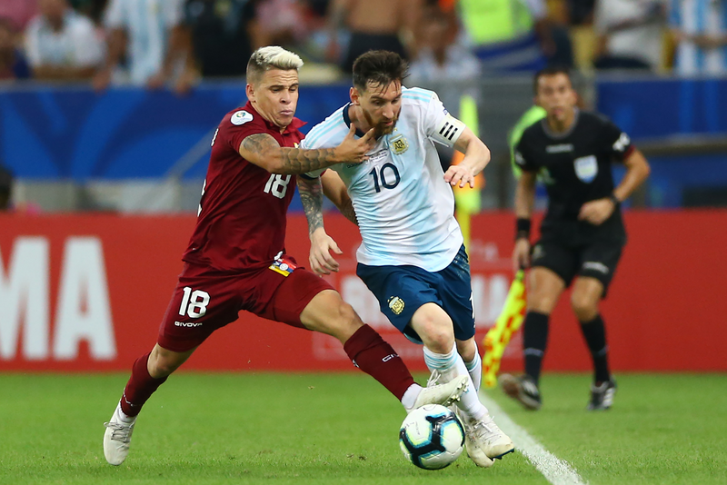 Lionel Messi of Argentina fights for the ball with Yeferson Soteldo