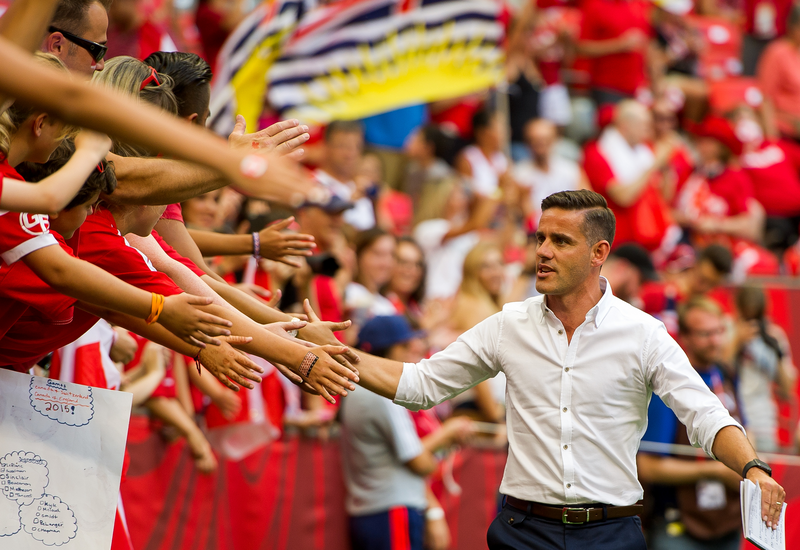 John Herdman Head Coach of Canada high fives fans on the way to the team room