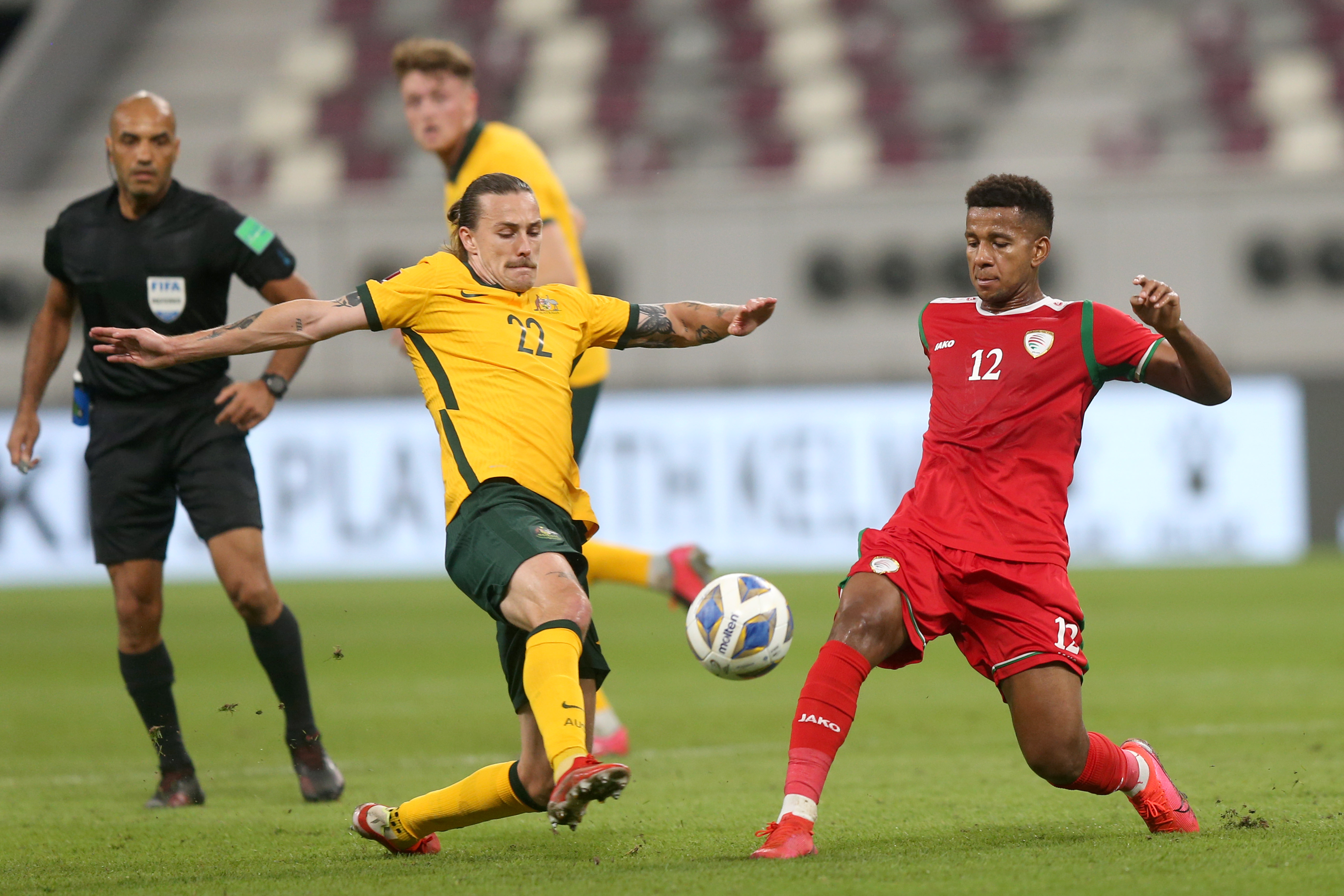 DOHA, QATAR - OCTOBER 07: Jackson Irvine of Australia and Abdullah Fawaz of Oman battle for the ball during the 2022 FIFA World Cup Qualifier match between Australia and Oman at Khalifa International Stadium on October 7, 2021 in Doha, Qatar. (Photo by Mohamed Farag/Getty Images)