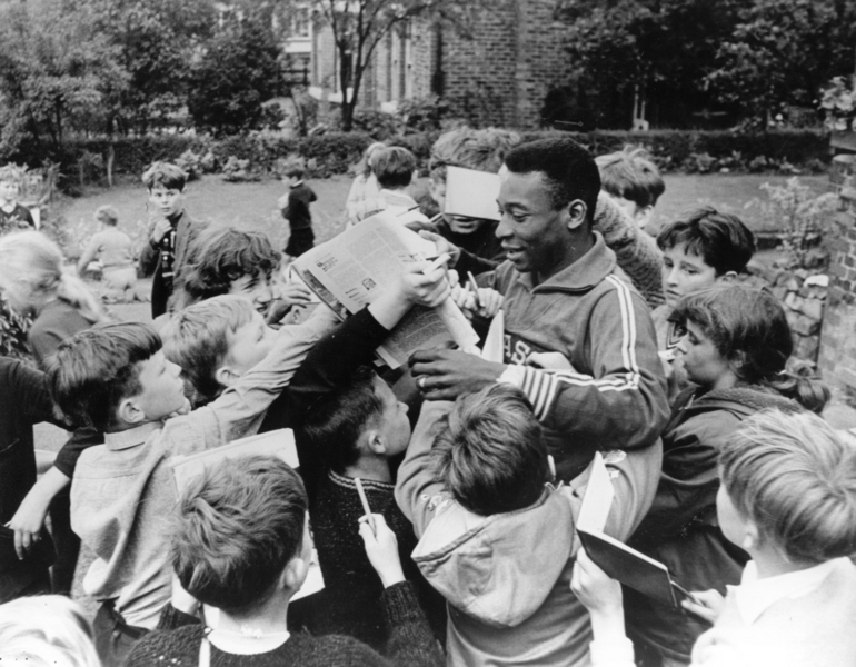 Pelé inmitten eines jungen Publikums, das während der FIFA-Weltmeisterschaft 1966 um Autogramme bittet.