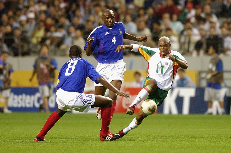 SEOUL - MAY 31: El Hadji Diouf (No.11) of Senegal takes the ball round Marcel Desailly (No.8) of France during the France v Senegal Group A, World Cup Group Stage match played at the Seoul World Cup Stadium, Seoul, South Korea on May 31, 2002. Senegal won the match 1-0