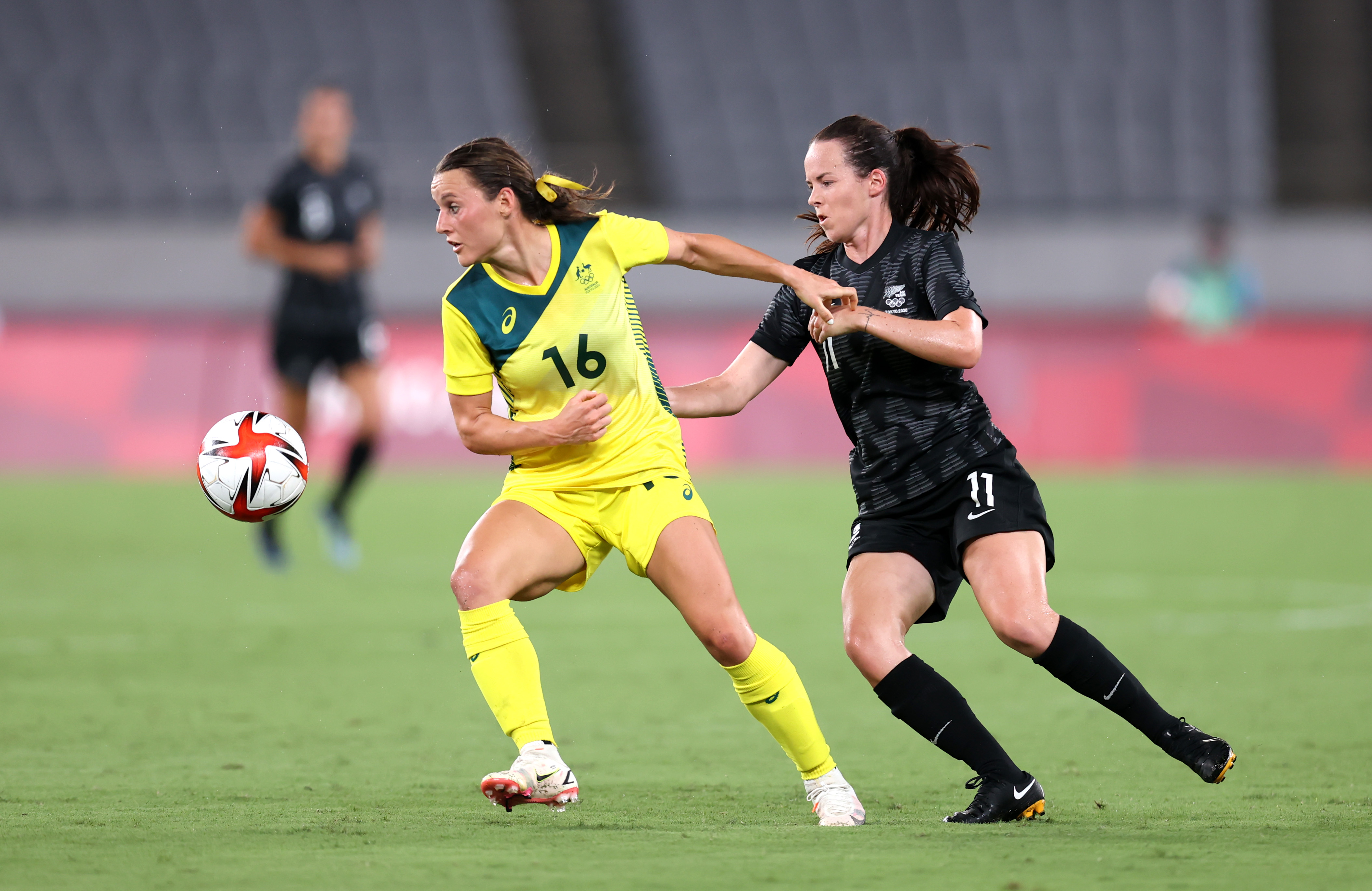 CHOFU, JAPAN - JULY 21: Hayley Raso #16 of Team Australia is challenged by Olivia Chance #11 of Team New Zealand during the Women's First Round Group G match between Australia and New Zealand during the Tokyo 2020 Olympic Games at Tokyo Stadium on July 21, 2021 in Chofu, Tokyo, Japan. (Photo by Alex Grimm - FIFA/FIFA via Getty Images)