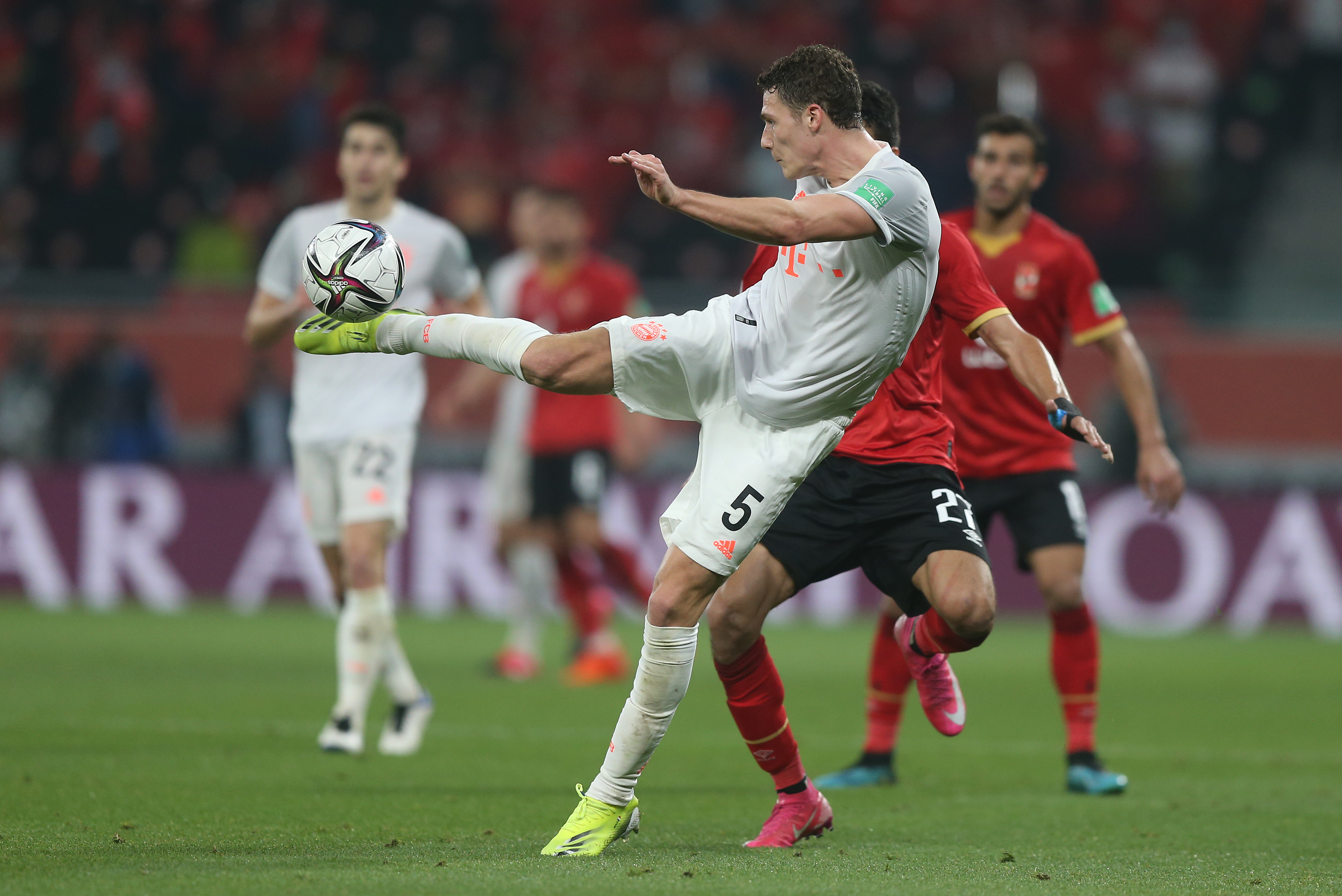 DOHA, QATAR - FEBRUARY 08: Benjamin Pavard of FC Bayern Muenchen stretches for the ball under pressure from Taher Mohamed of Al Ahly SC during the Semi-Final match between Al Ahly SC and FC Bayern Muenchen at the Ahmad Bin Ali Stadium on February 08, 2021 in Doha, Qatar. (Photo by Mohamed Farag - FIFA/FIFA via Getty Images)