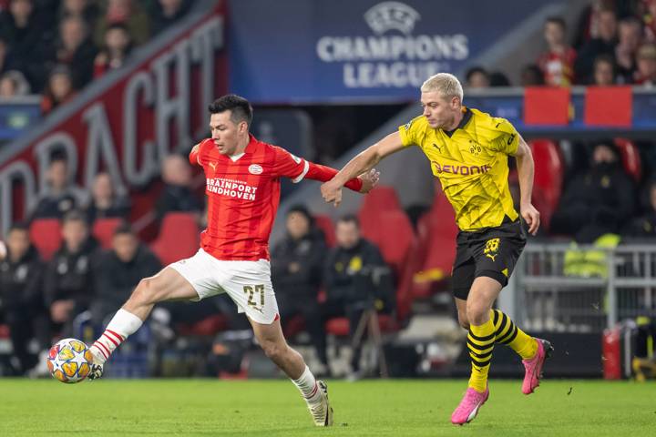 Hirving Lozano of PSV Eindhoven is tackled by Julian Ryerson of Borussia Dortmund during the UEFA Champions League 2023/24 round of 16 first leg match between PSV Eindhoven and Borussia Dortmund