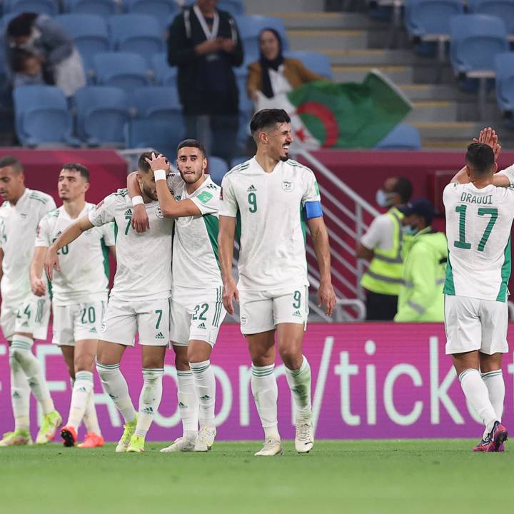 AL WAKRAH, QATAR - DECEMBER 04: Tayeb Meziani of Algeria (obscured) celebrates with teammates, embracing Zineddine Boutmene, after scoring their team's second goal during the FIFA Arab Cup Qatar 2021 Group D match between Lebanon and Algeria at Al Janoub Stadium on December 04, 2021 in Al Wakrah, Qatar. (Photo by Maddie Meyer - FIFA/FIFA via Getty Images)