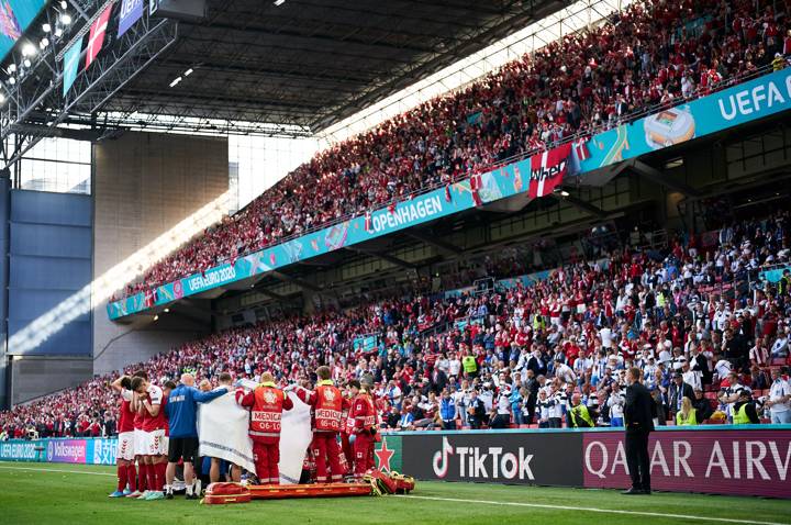 Denmark's players gather around Denmark's midfielder Christian Eriksen after collapseing on the pitch during the UEFA EURO 2020 Group B football match between Denmark and Finland at the Parken Stadium in Copenhagen on June 12, 2021.