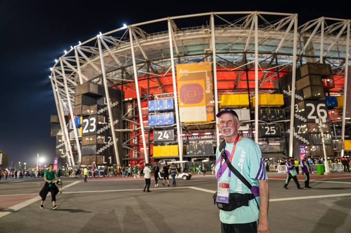 A volunteer, Hubert Bihler, poses a picture in front of 974 Stadium