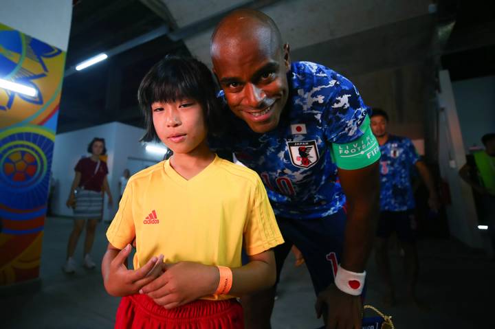 Ozu Moreira of Japan poses with a player escort kid