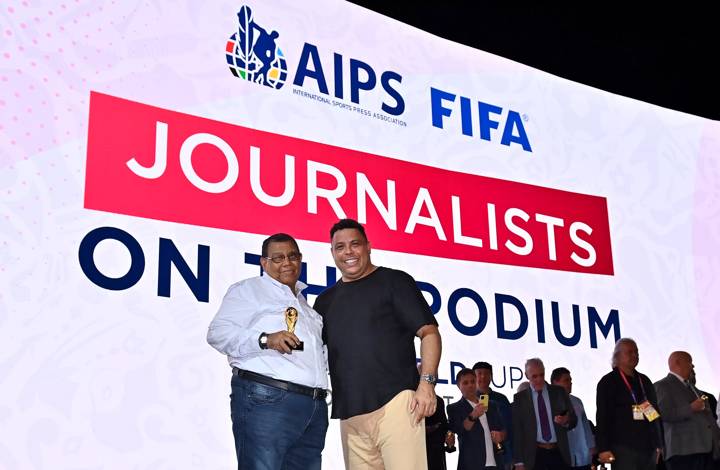 Jesús Vélez Vanegas is presented with a world cup replica trophy