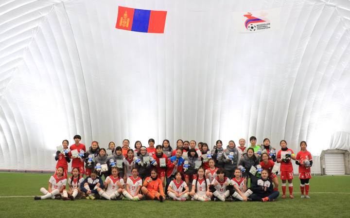 Players gather for a photo after a friendly between hosts Mongolia and Hong Kong U-17 women's teams in the newly constructed air-dome at the MFF National Teams Training Centre