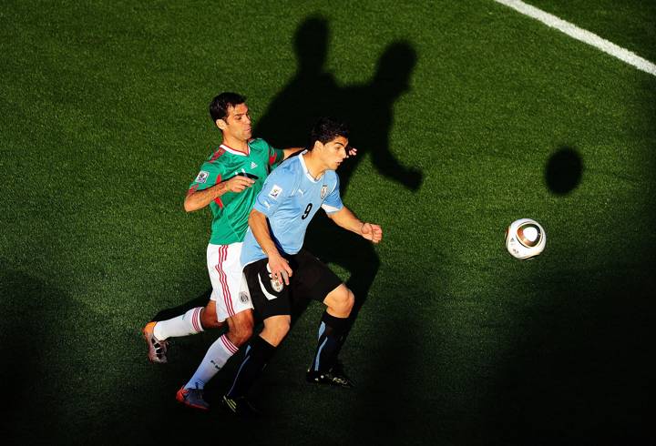 Luis Suarez of Uruguay (R) is challenged by Rafael Marquez