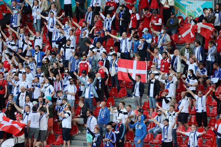 Finland and Denmark fans chant in support of Denmark's midfielder Christian Eriksen after he was evacuated from the pitch during the UEFA EURO 2020 Group B football match between Denmark and Finland at the Parken Stadium in Copenhagen on June 12, 2021. 