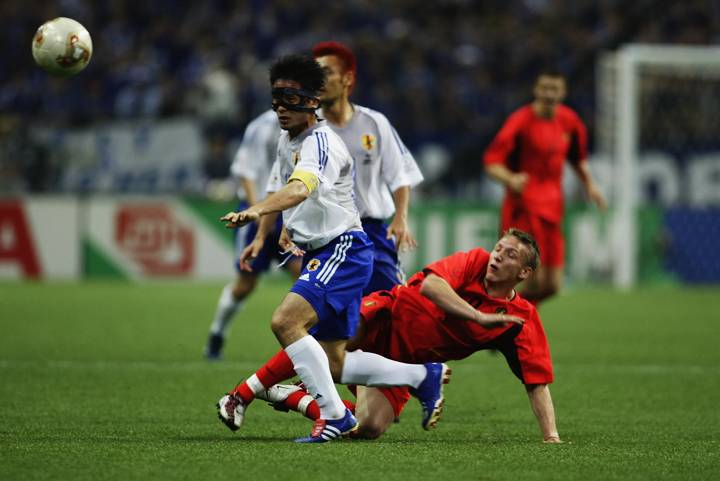 Tsuneyasu Miyamoto of Japan wins the tackle from Wesley Sonck of Belgium 