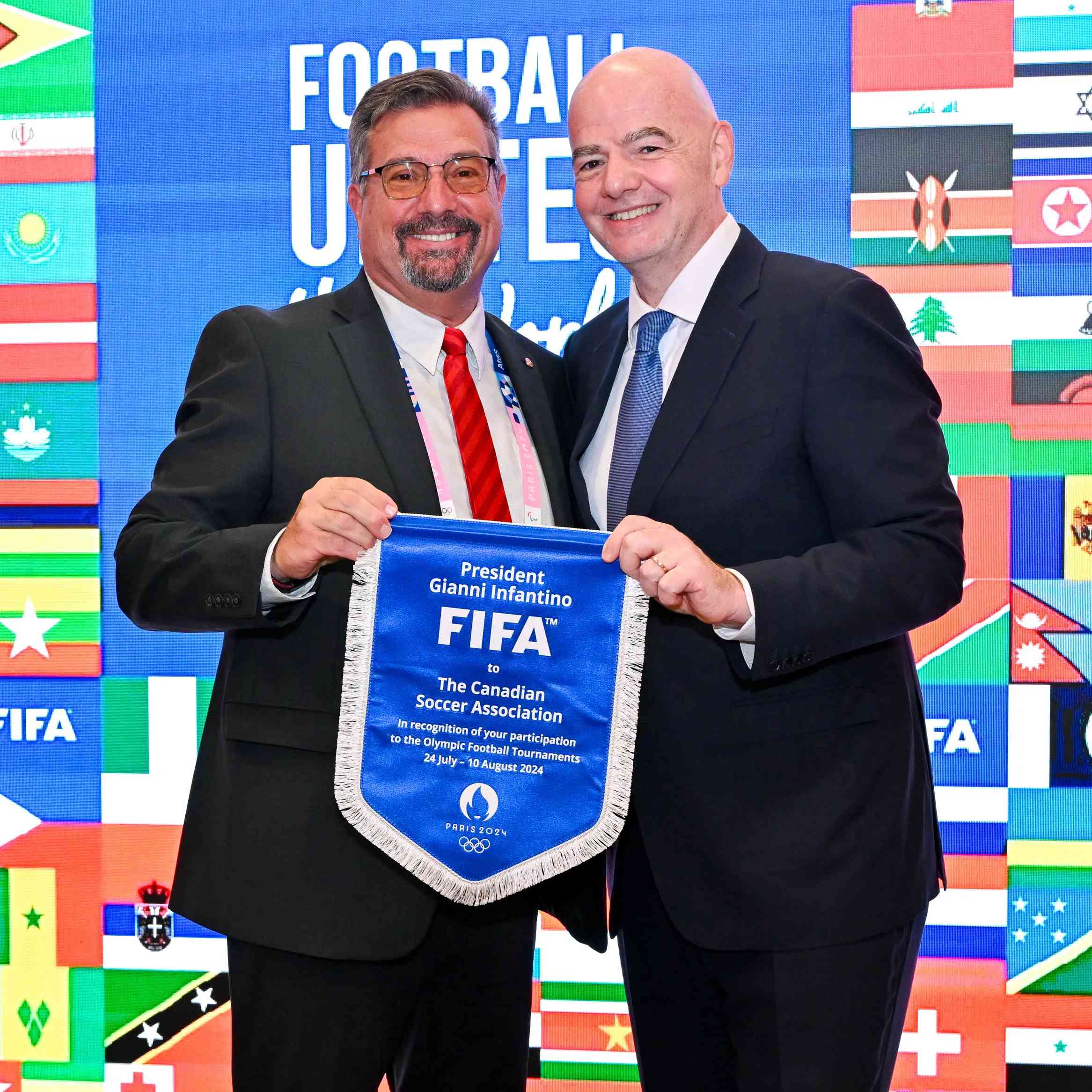 PARIS, FRANCE - JULY 22: FIFA President Gianni Infantino and The Canadian Soccer Association President Peter Augruso pose for a photo with pennant during the Celebratory Lunch on the sidelines of the Olympic Games Paris 2024 at FIFA Paris offices on July 22, 2024 in Paris, France. (Photo by Harold Cunningham/FIFA)