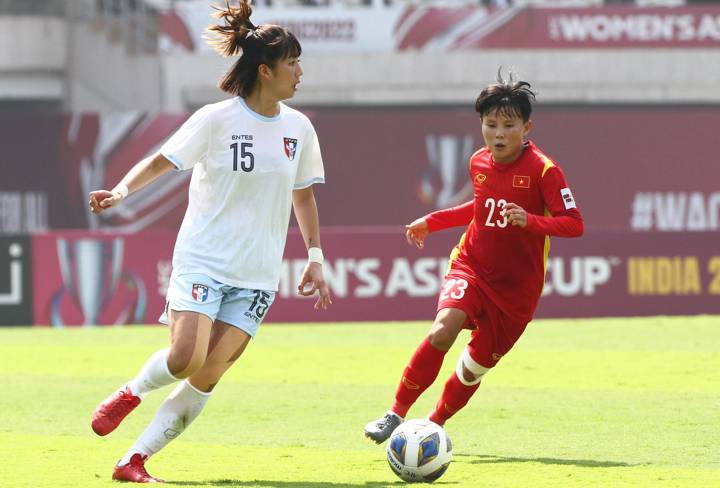 Vietnam midfielder Nguyen Thi Bich Thuy (R) dribbles the ball past an opponent