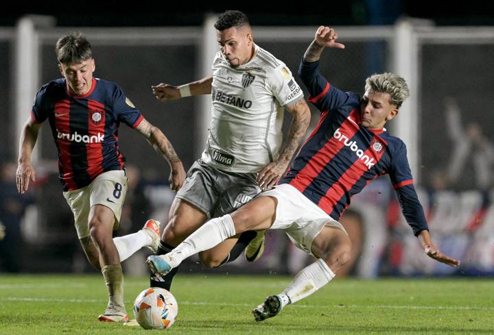 Atletico Mineiro's forward Paulinho (C), San Lorenzo's midfielder Elian Irala (R) and San Lorenzo's forward Matías Reali fight for the ball 