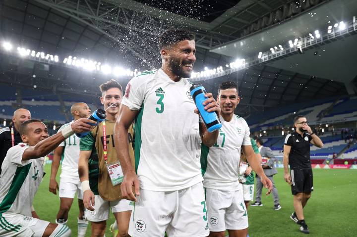 Hocine Benayada of Algeria is splashed by teammates with Poweraid water bottles celebrating victory following the FIFA Arab Cup Qatar 2021 Group D match between Lebanon and Algeria 