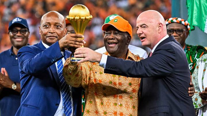 President of the Confederation of African Football (CAF) Patrice Motsepe (L), President of Ivory Coast Alassane Ouattara (C) and President of FIFA Gianni Infantino (R) hold the Africa Cup of Nations trophy after Ivory Coast won the Africa Cup of Nations (CAN) 2024 final football match between Ivory Coast and Nigeria at Alassane Ouattara Olympic Stadium in Ebimpe, Abidjan on February 11, 2024. (Photo by Sia KAMBOU / AFP) (Photo by SIA KAMBOU/AFP via Getty Images)