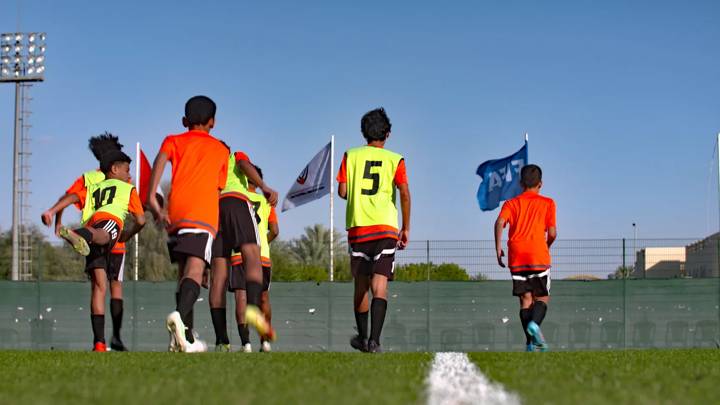 Children playing football under FIFA Forward funded floodlights in the UAE