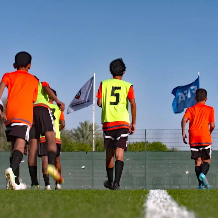 Children playing football under FIFA Forward funded floodlights in the UAE