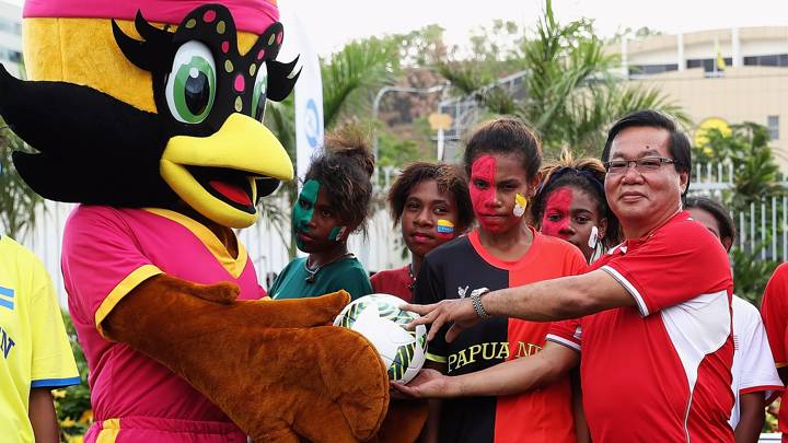 PORT MORESBY, PAPUA NEW GUINEA - NOVEMBER 12:  PNG Football Association president, David Chung receives a match ball from Susa, the official mascot during the opening of the FanZoneat Vision City Mega Mall on November 12, 2016 in Port Moresby, Papua New Guinea.  (Photo by Matthew Lewis - FIFA/FIFA via Getty Images)