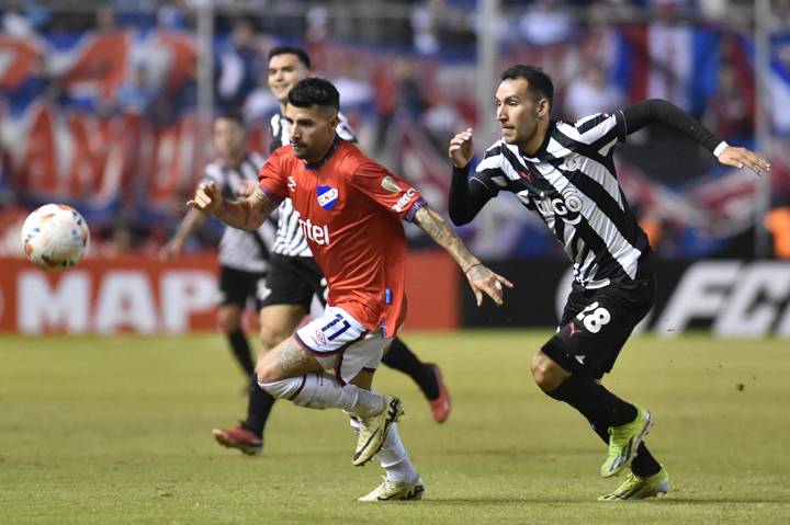 Nacional's Argentine defender Gabriel Baez (L) and Libertad's forward Marcelo Fernandez (R) fight for the ball