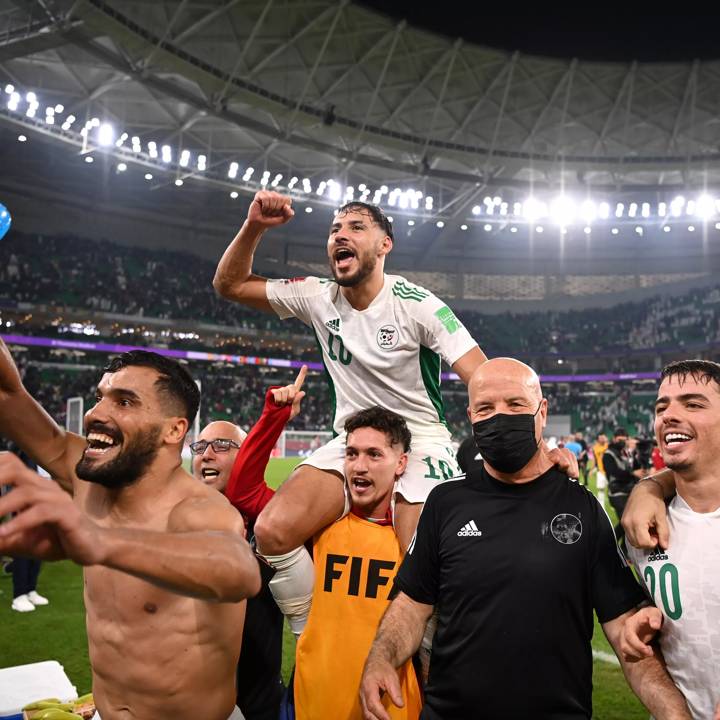 DOHA, QATAR - DECEMBER 15: Mohammed Belaili of Algeria is carried by Aimen Bouguerra as he celebrates with teammates following the FIFA Arab Cup Qatar 2021 Semi-Final match between Qatar and Algeria at Al Thumana Stadium on December 15, 2021 in Doha, Qatar. (Photo by Michael Regan - FIFA/FIFA via Getty Images)