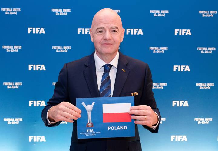 FIFA President Gianni Infantino holds up a sign announcing Poland as the hosts for the FIFA U-20 Women's World Cup 2026 