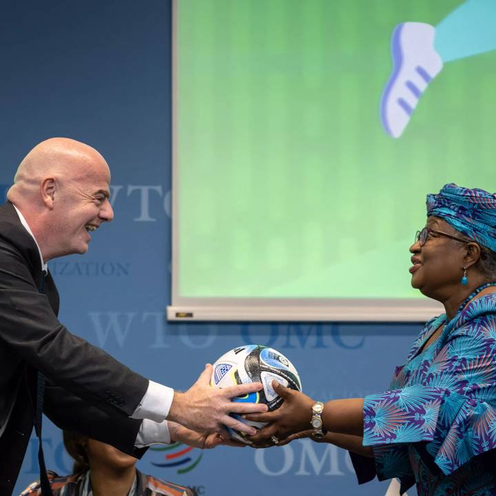 World Trade Organization (WTO) Director-General Ngozi Okonjo-Iweala (R) receives an official ball of the 2023 FIFA Women's World Cup from FIFA President Gianni Infantino during a "Making trade score for women!" discussion on football as a tool for trade and development at the WTO headquarters in Geneva, on May 1, 2023. (Photo by Fabrice COFFRINI / AFP) (Photo by FABRICE COFFRINI/AFP via Getty Images)