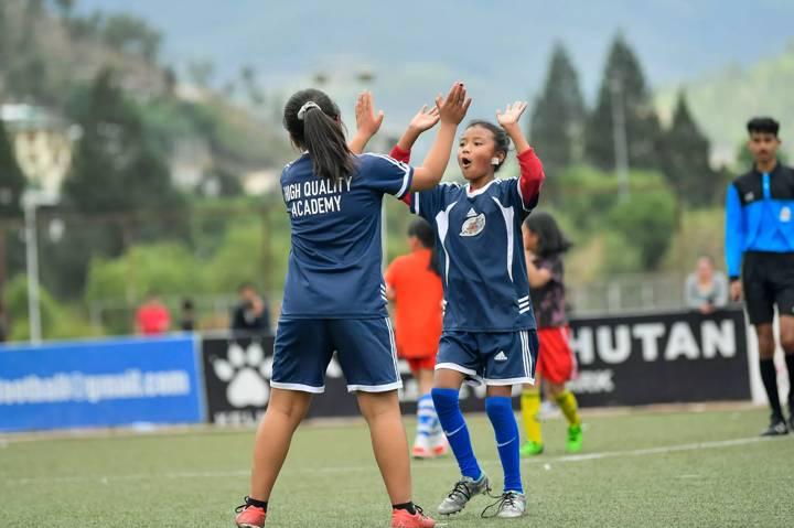 Young Bhutanese players celebrate after scoring a goal 