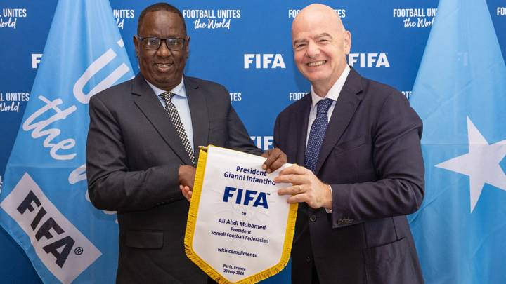 PARIS, FRANCE - JULY 29: FIFA President Gianni Infantino and Somali Football Federation President (SFF) Ali Abdi Mohamed pose for a photo with a pennant after a meeting between FIFA and SFF at FIFA's Paris office on July 29, 2024 in Paris, France. (Photo by Léo-Paul Ridet/FIFA)